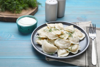 Photo of Delicious dumplings with dill on turquoise wooden table
