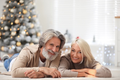 Photo of Happy couple lying on floor at home. Christmas eve
