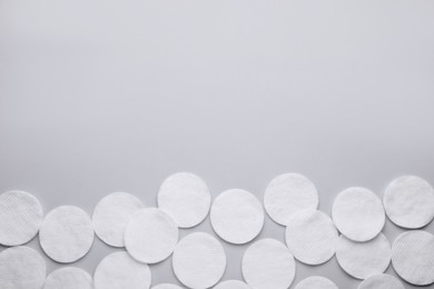 Photo of Many clean cotton pads on light grey background, flat lay. Space for text