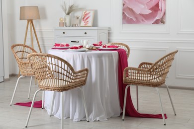 Color accent table setting. Plates, cutlery and pink napkins in dining room