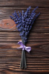 Photo of Bouquet of beautiful preserved lavender flowers on wooden table, top view