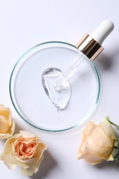 Photo of Petri dish with sample of cosmetic serum, pipette and rose flowers on white background, flat lay