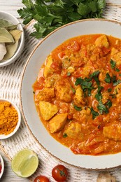 Photo of Delicious chicken curry and ingredients on table, top view