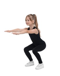 Photo of Little girl doing squats on white background. Morning exercise