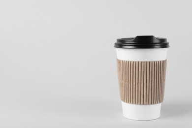 Paper cup with plastic lid on light background, space for text. Coffee to go