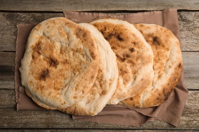 Photo of Delicious fresh pita bread on wooden table, top view