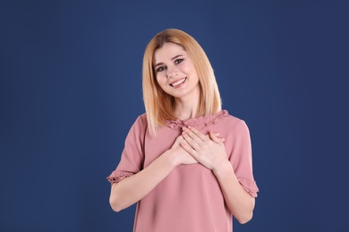 Photo of Portrait of woman holding hands near heart on color background
