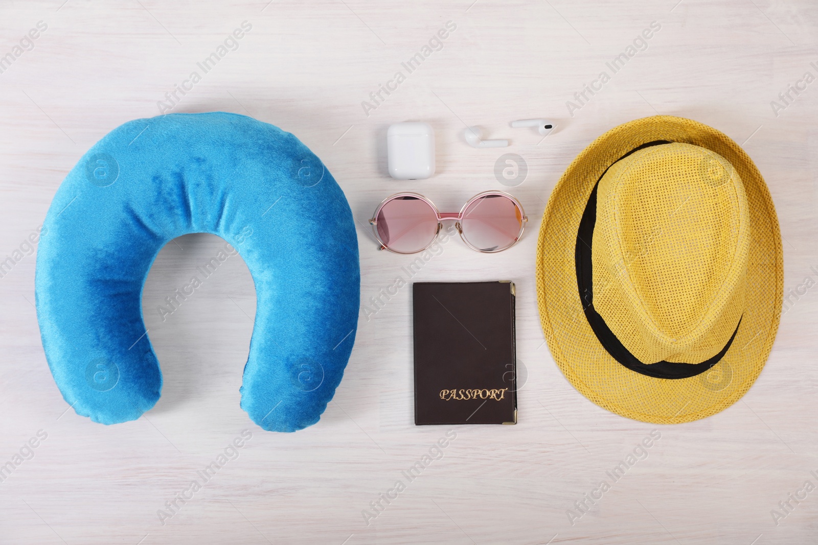 Photo of Flat lay composition with light blue travel pillow on white wooden background