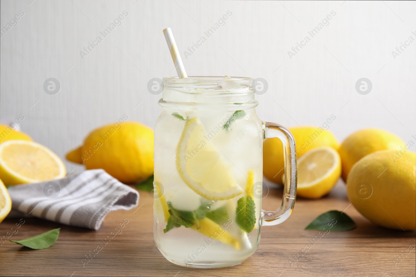 Photo of Mason jar of cold lemonade on wooden table