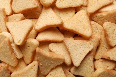 Photo of Heap of crispy rusks as background, top view