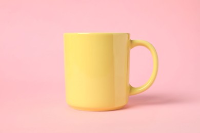 Photo of One yellow ceramic mug on pink background