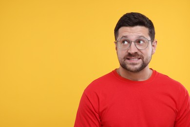 Photo of Embarrassed man on orange background. Space for text