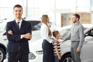 Photo of Salesman and young family in car salon