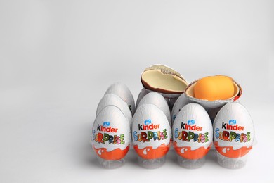 Photo of Sveti Vlas, Bulgaria - June 26, 2023: Kinder Surprise Eggs and capsule with toy in plastic tray on white background. Space for text