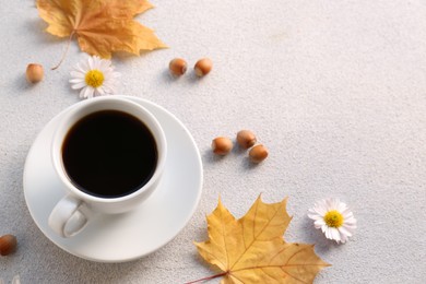 Photo of Composition with cup of hot drink and autumn leaves on light grey textured table, above view