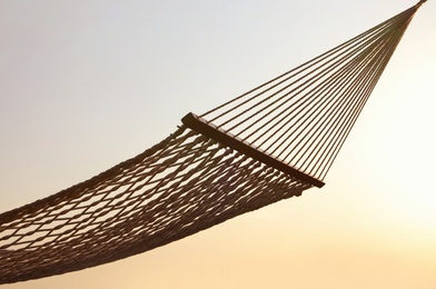 Photo of Empty hammock hanging outdoors. Time to relax