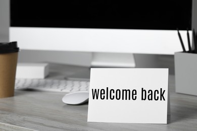 Image of Paper note with phrase Welcome Back on office desk