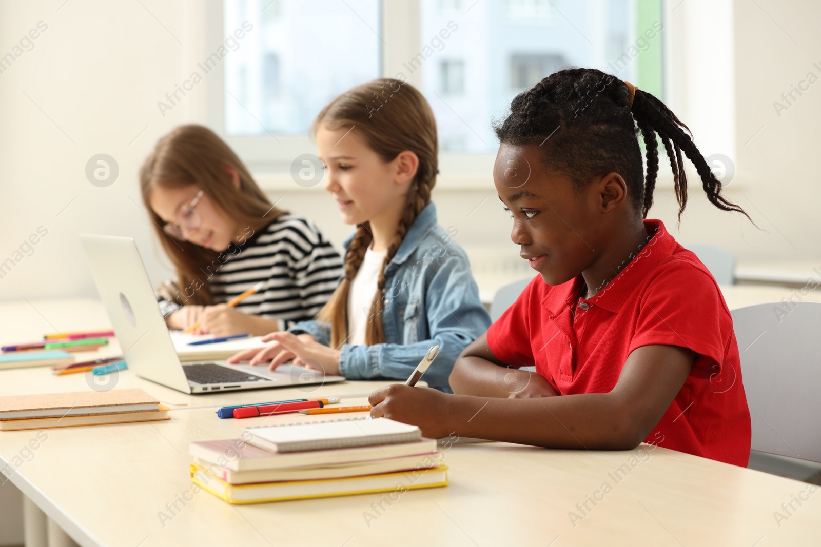 Photo of Cute children studying in classroom at school