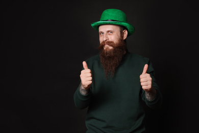 Photo of Bearded man in green hat on black background. St. Patrick's Day celebration