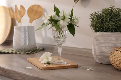 Beautiful jasmine flowers on wooden table indoors