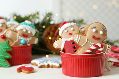 Photo of Delicious homemade Christmas cookies in bowl on white wooden table against blurred festive lights. Space for text