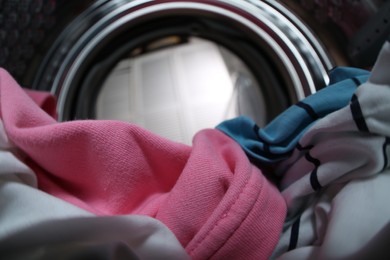 Clothes in washing machine indoors, view from inside. Laundry day