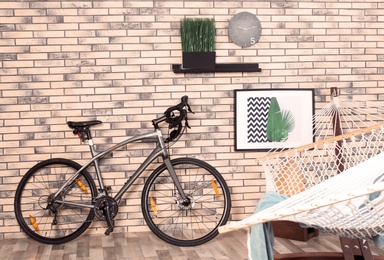 Photo of Modern bicycle and hammock in stylish room interior