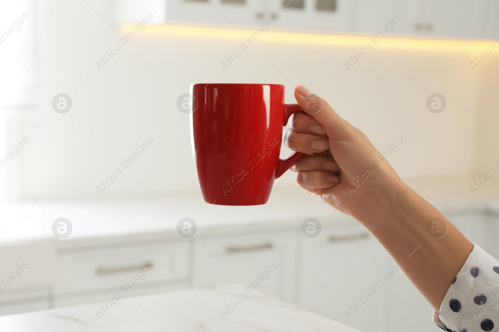 Photo of Woman with red cup at home, closeup