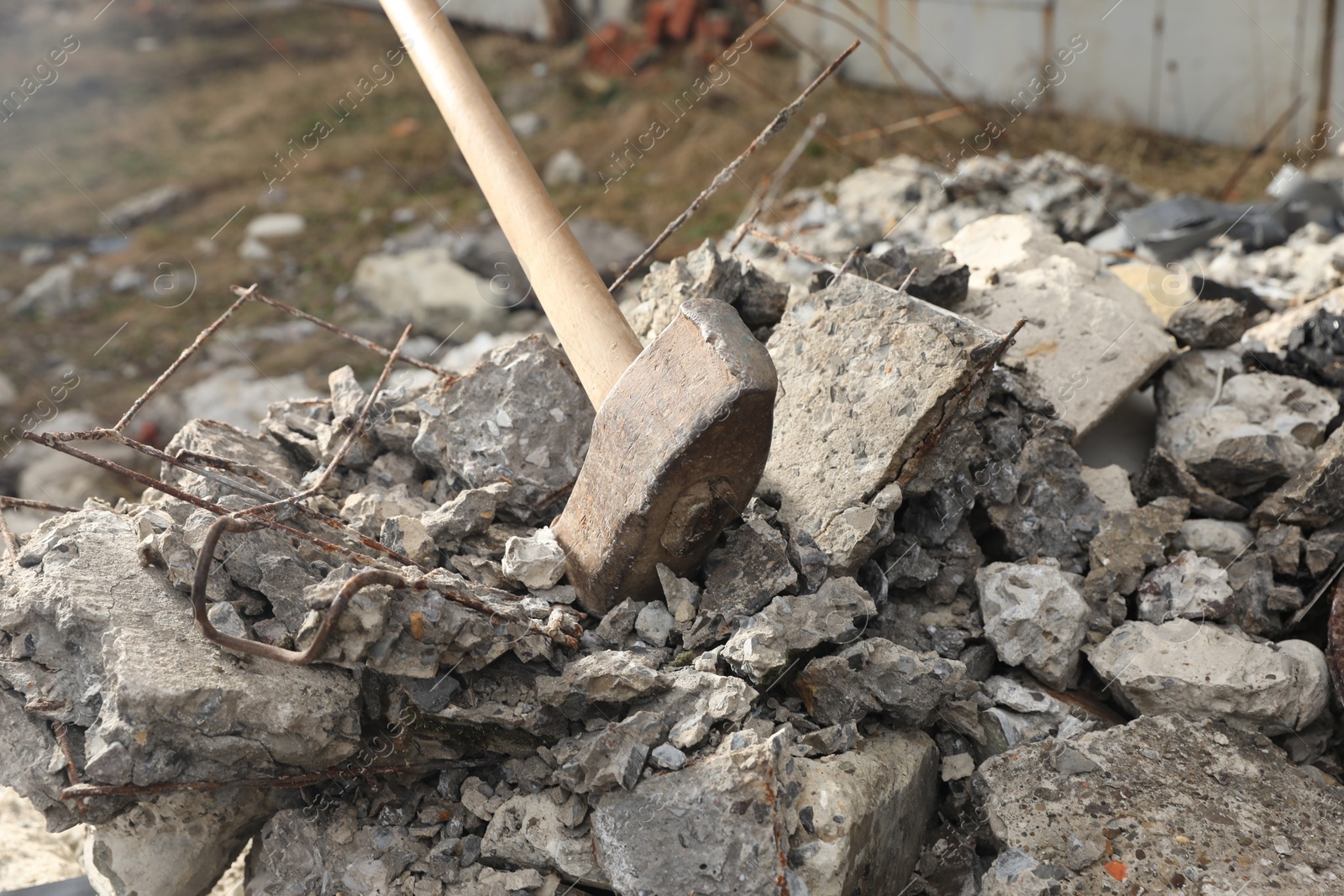 Photo of Sledgehammer on pile of broken stones outdoors, closeup