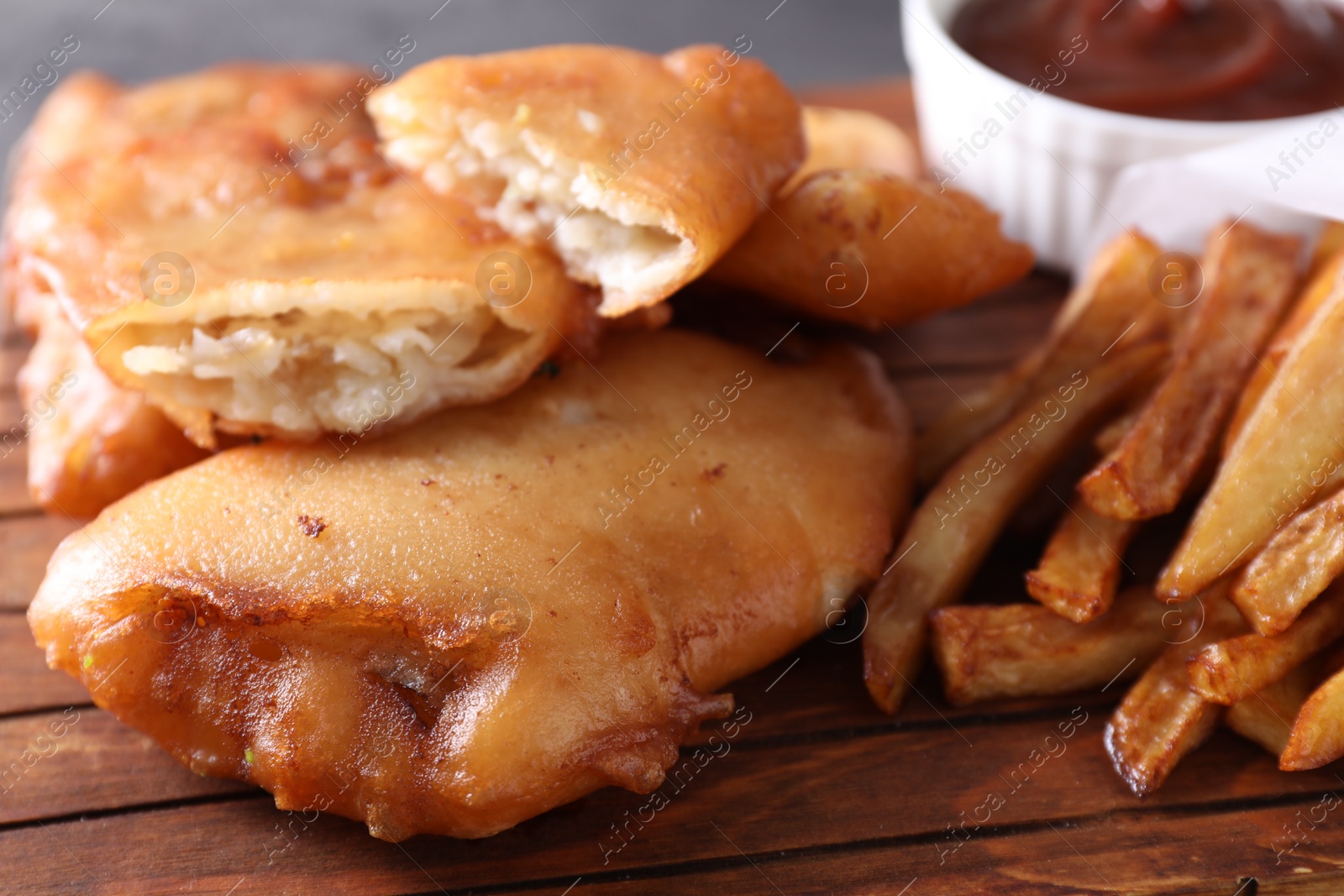 Photo of Tasty fish, chips and sauce on table, closeup