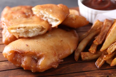 Photo of Tasty fish, chips and sauce on table, closeup