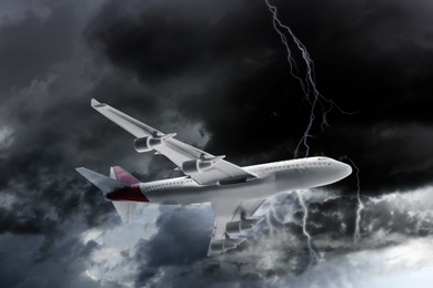 Image of Airplane flying in cloudy sky during thunderstorm