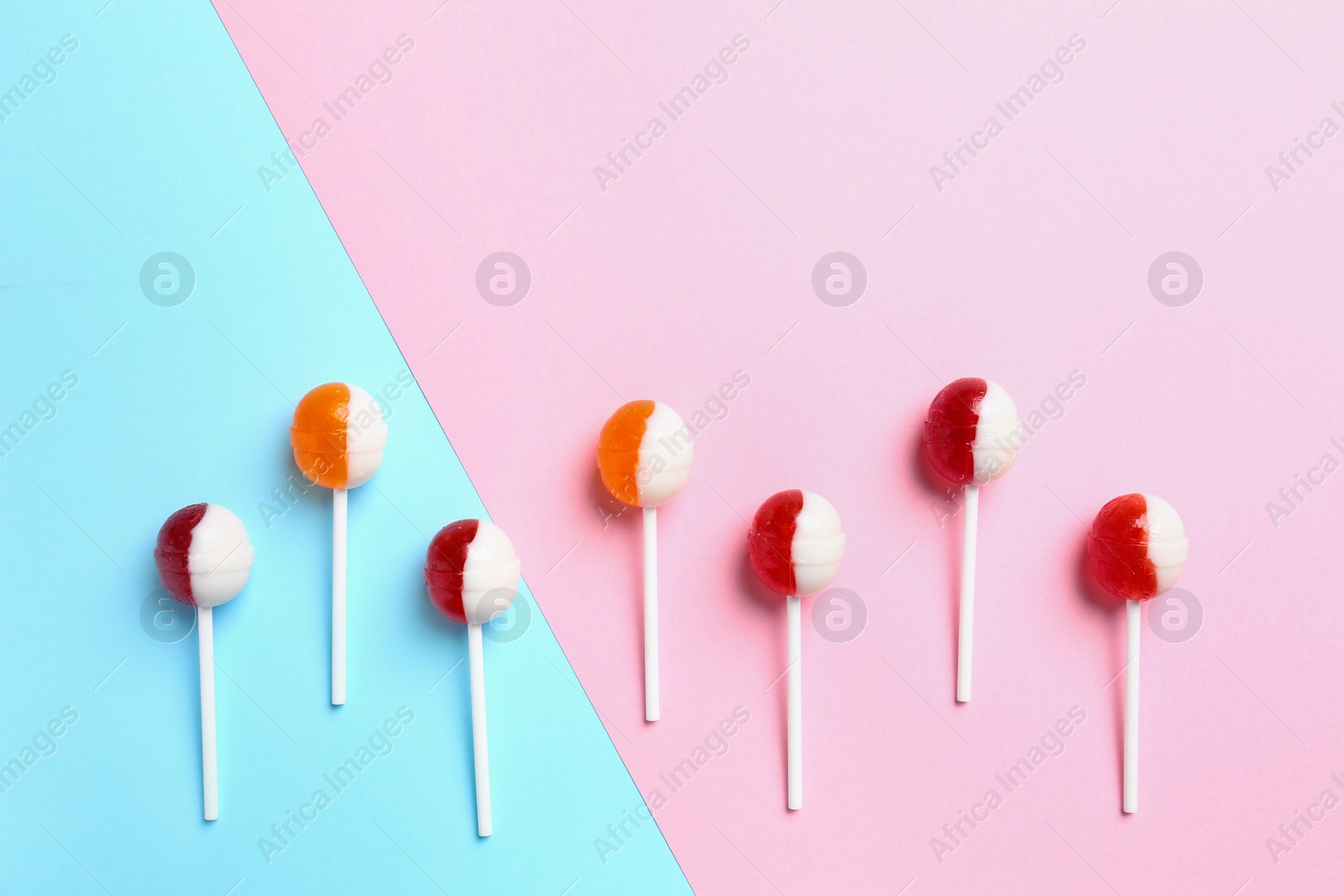 Photo of Delicious lollipop candies on color background. Space for text