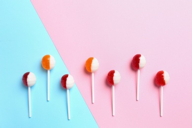 Photo of Delicious lollipop candies on color background. Space for text