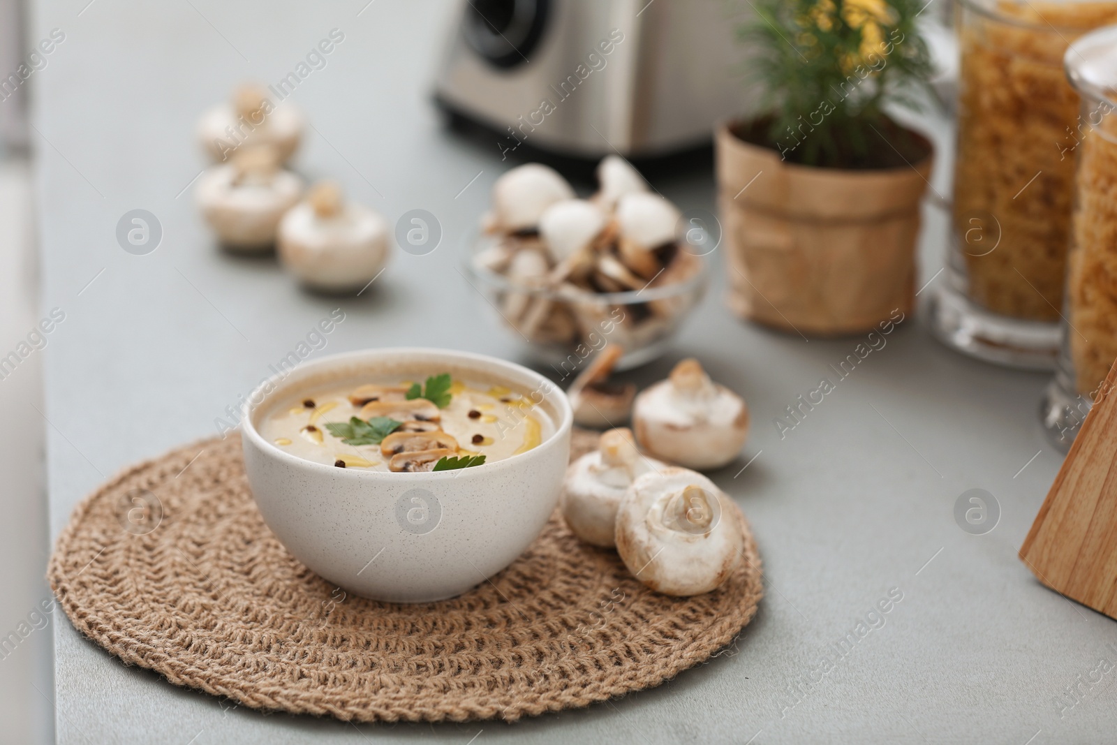 Photo of Delicious cream soup with mushrooms on grey table