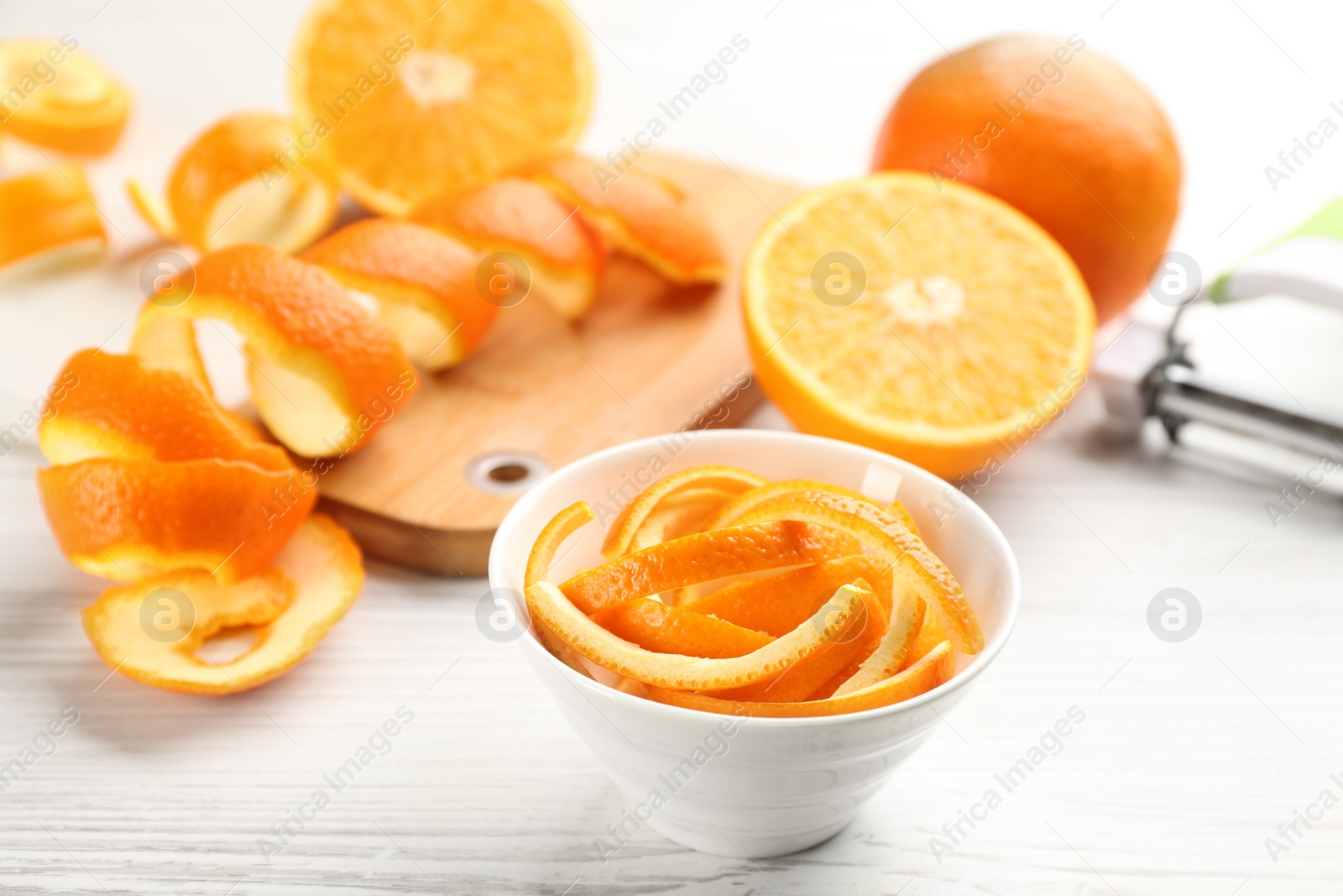 Photo of Orange fruits and peels on white wooden table