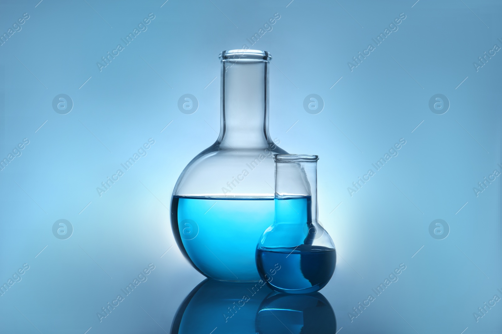 Photo of Flasks with liquid on table against color background. Laboratory analysis