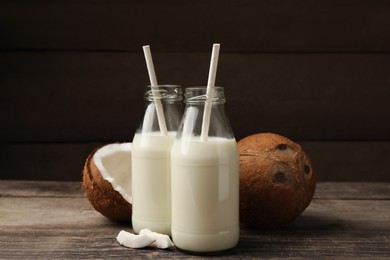 Photo of Delicious vegan milk and coconuts on wooden table