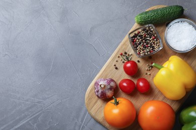 Photo of Different vegetables and seasonings on grey table, top view. Space for text