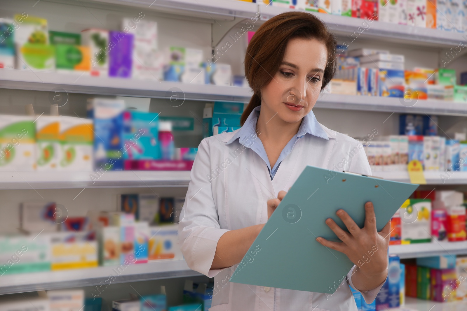 Photo of Professional pharmacist with clipboard in modern drugstore