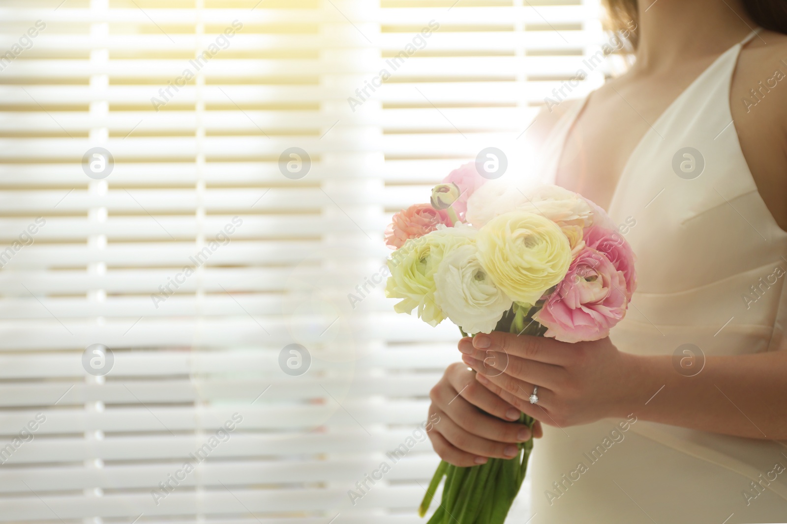 Photo of Bride with beautiful ranunculus bouquet indoors, closeup. Space for text