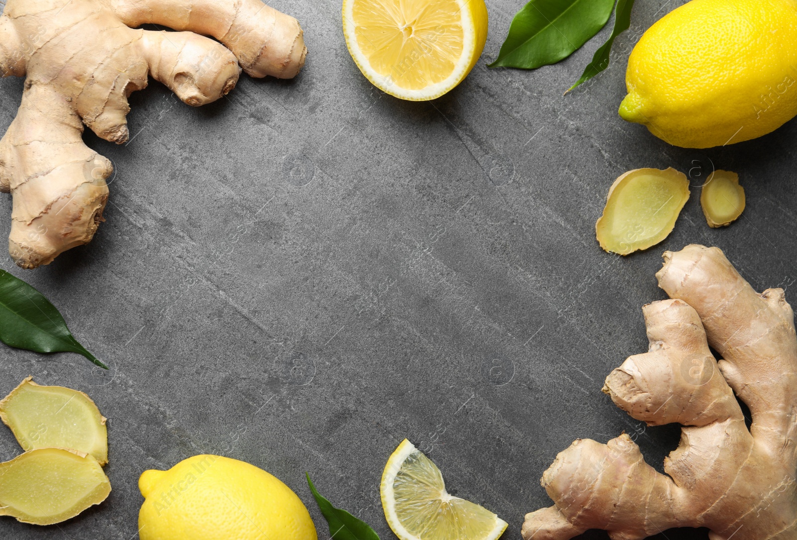 Photo of Frame of fresh lemons and ginger on grey table, flat lay. Space for text