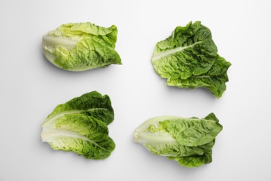 Photo of Fresh green romaine lettuces and leaves isolated on white, top view