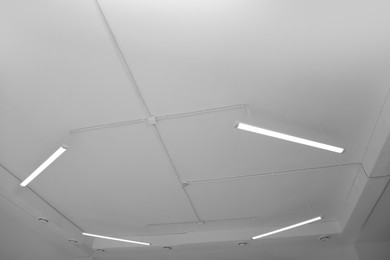 Photo of White ceiling with modern lighting in office