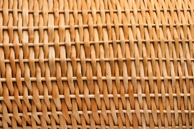 Handmade wicker basket made of natural material as background, closeup view