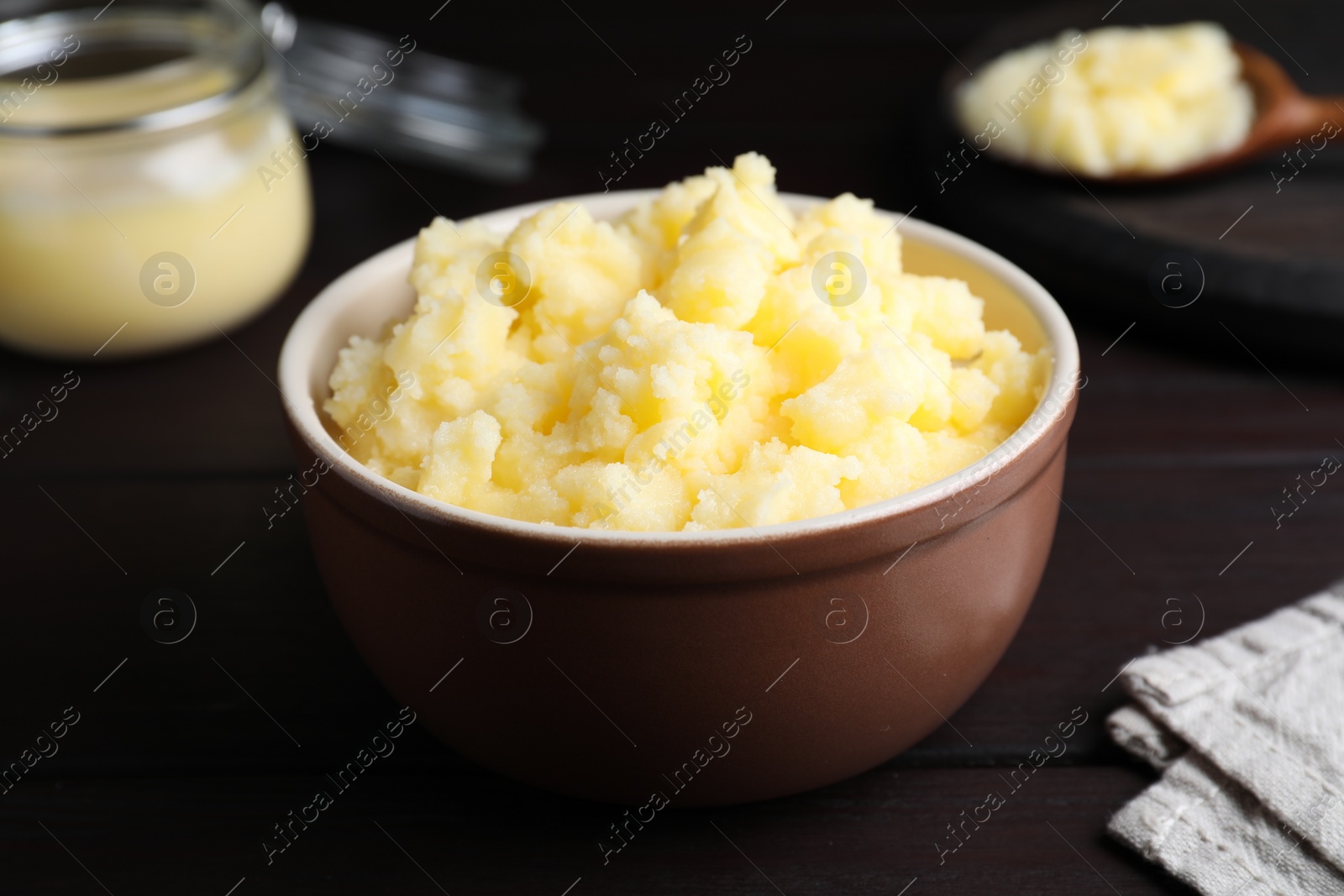 Photo of Bowl of Ghee butter on wooden table, closeup