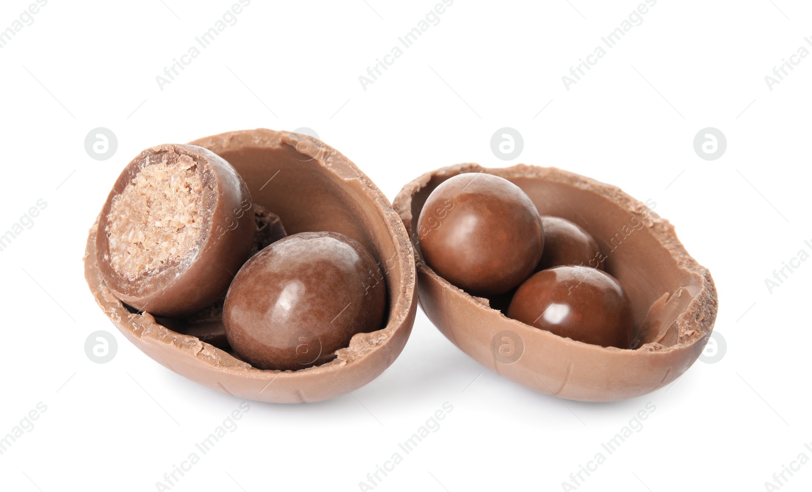 Photo of Broken chocolate Easter egg with candies on white background