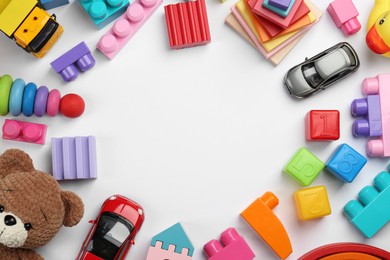 Frame of different children's toys on white background, flat lay. Space for text