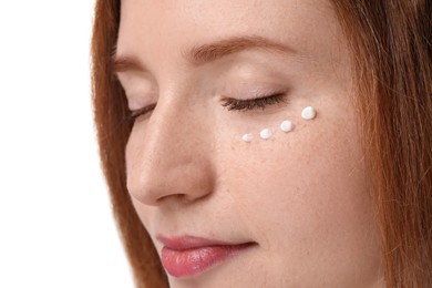 Beautiful woman with freckles and cream on her face against white background, closeup