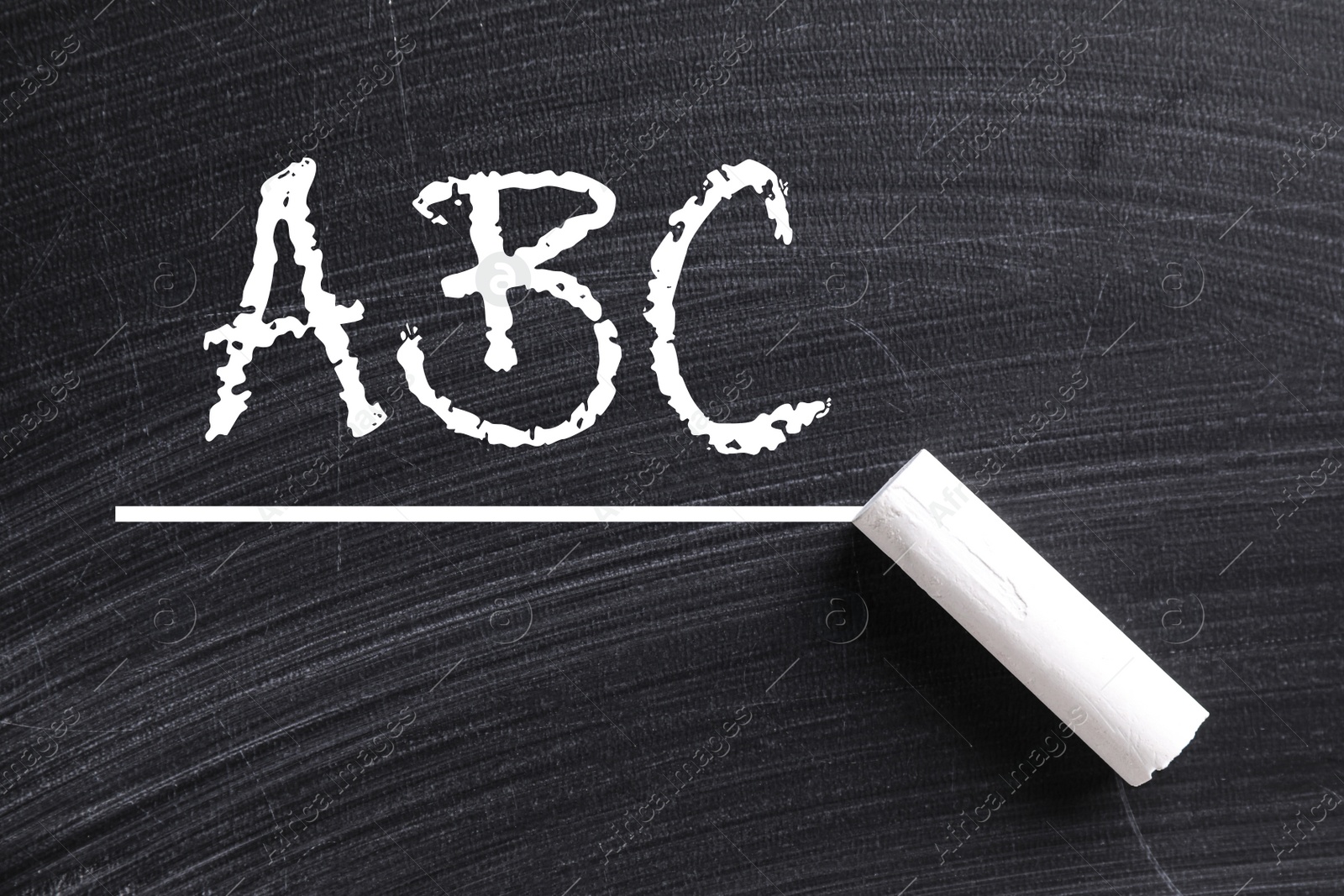 Image of Piece of white chalk and letters ABC written on blackboard, top view